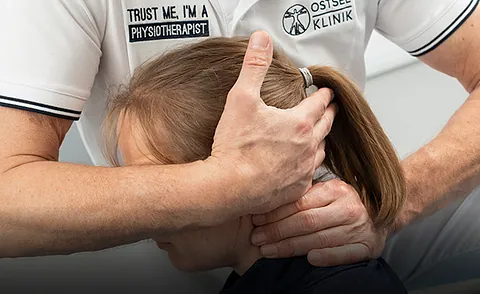 Physiotherapeut führt manuelle Therapie im Nackenbereich in der Praxis in Bad Schwartau durch