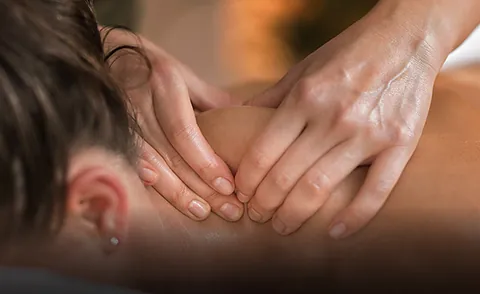 Massagebehandlung im Schulter- und Nackenbereich zur Lockerung der Muskulatur